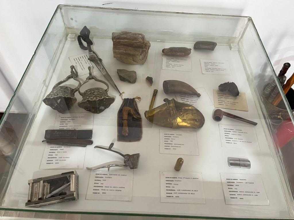 Peças antigas catalogadas em vitrine de vidro