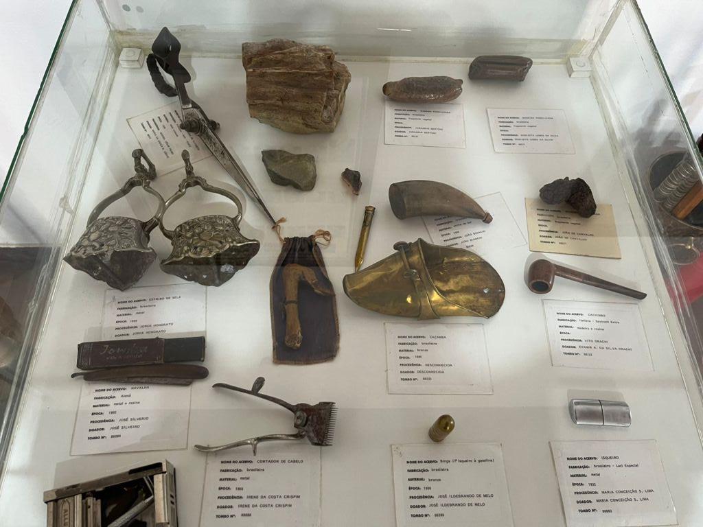 Utensílios antigos e peças catalogadas em vitrine de vidro