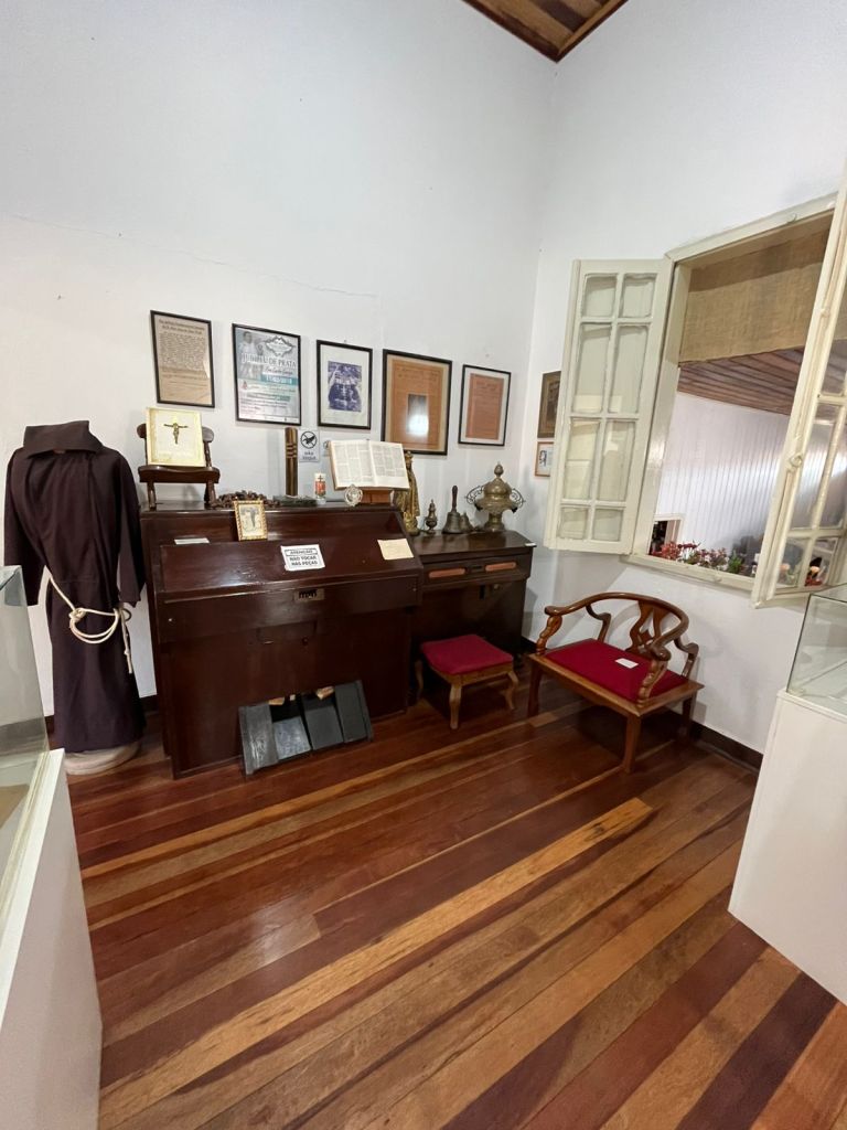 Sala religiosa com documentos, mobiliário e vestimenta