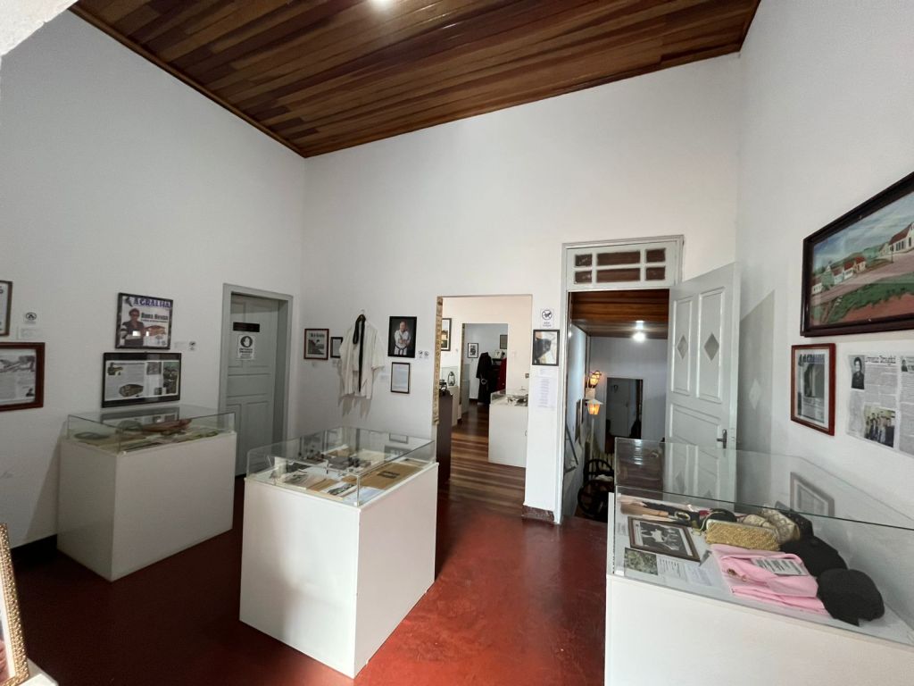 Sala expositiva com vitrines e recortes de jornal