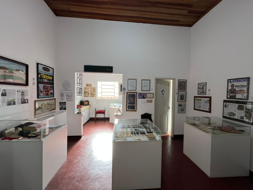 Sala com vitrines, jornais e registros históricos